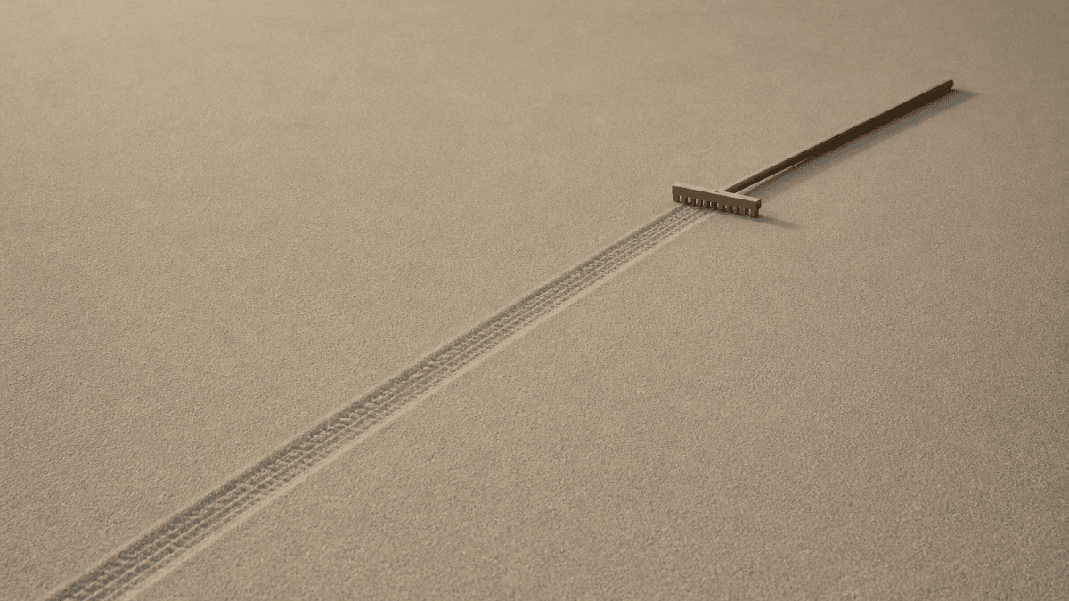 Wide smooth sand surface with a single narrow raked strip and a wooden rake at the end of the track