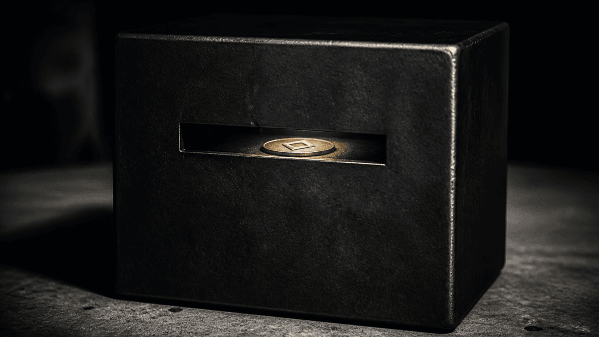 Seamlessly welded steel box without a keyhole on concrete, with a minted coin visible through a viewing slit