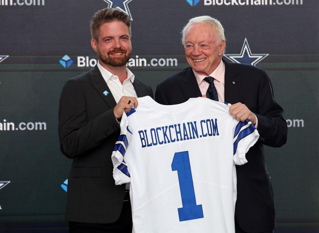 Dallas Cowboys owner Jerry Jones (R) presents Blockchain.com CEO Peter Smith with a jersey after announcing a historic partnership at The Star in Frisco on April 13, 2022 in Frisco, Texas.